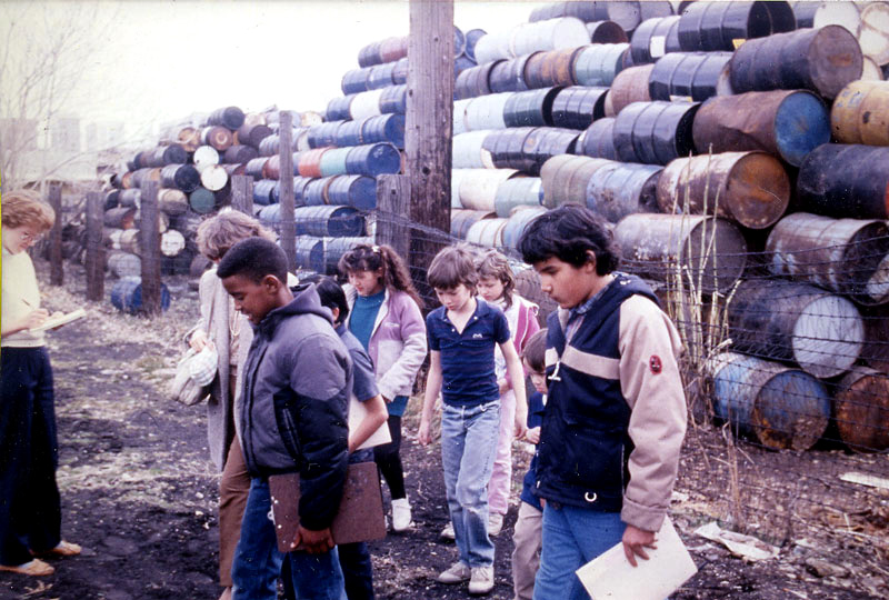 Jackson Elementary School students tour a hazardous waste storage facility located only three blocks from their school. The students successfully lobbied the State legislature to have the toxic dump designated a US EPA Superfund site, slated for cleanup.
