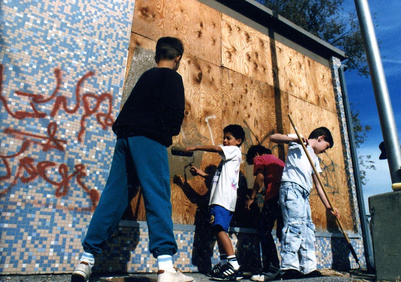 Students remove graffiti on a local building.